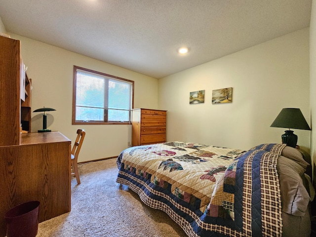 bedroom with a textured ceiling and light colored carpet