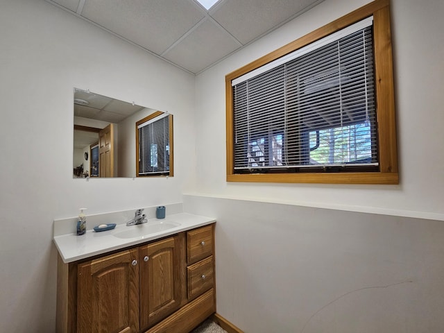 bathroom with a paneled ceiling and vanity