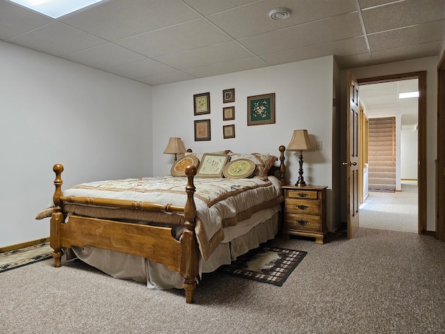 bedroom featuring carpet flooring and a drop ceiling