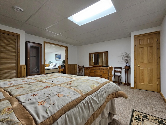 carpeted bedroom with a drop ceiling