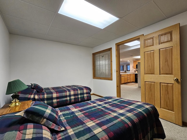 bedroom featuring light carpet, a paneled ceiling, and freestanding refrigerator