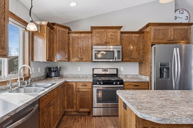 kitchen featuring vaulted ceiling, stainless steel appliances, a sink, and light countertops