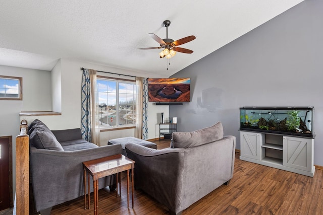 living area with lofted ceiling, a textured ceiling, wood finished floors, a ceiling fan, and baseboards