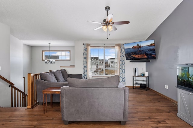 living area with dark wood-style floors, baseboards, and ceiling fan with notable chandelier