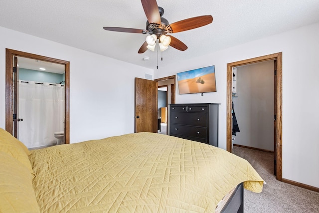 carpeted bedroom with visible vents, connected bathroom, baseboards, and a textured ceiling