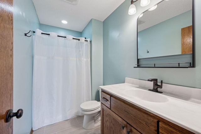 bathroom featuring toilet, curtained shower, and vanity