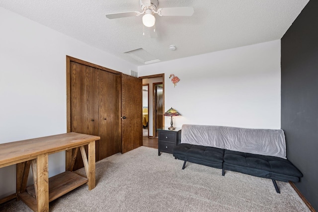 living area with light carpet, ceiling fan, and a textured ceiling