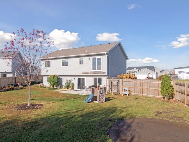 rear view of house featuring a patio area, a lawn, and a fenced backyard