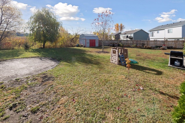 view of yard with a storage shed, an outbuilding, and fence