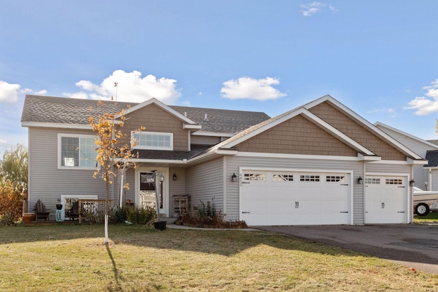 view of front of property featuring a front yard, roof with shingles, driveway, and an attached garage