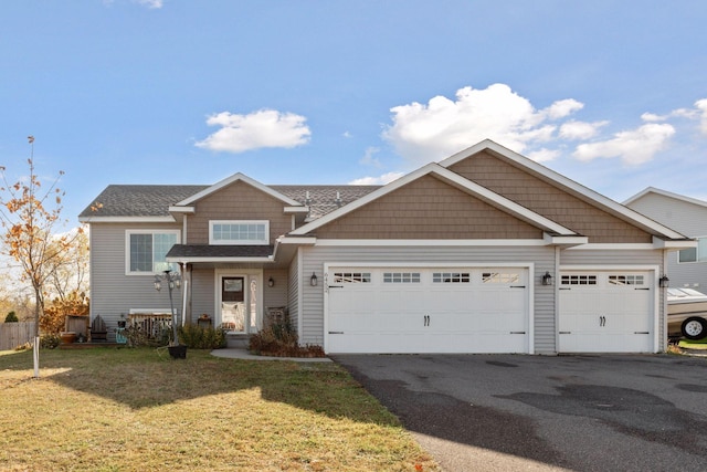 view of front of house with a front lawn, driveway, a shingled roof, and an attached garage