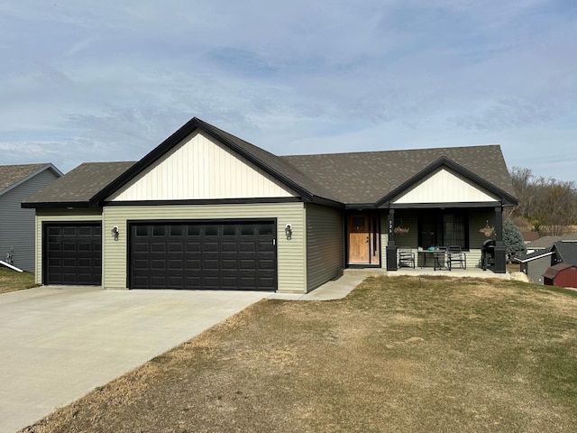 view of front facade featuring a porch, a front lawn, and a garage