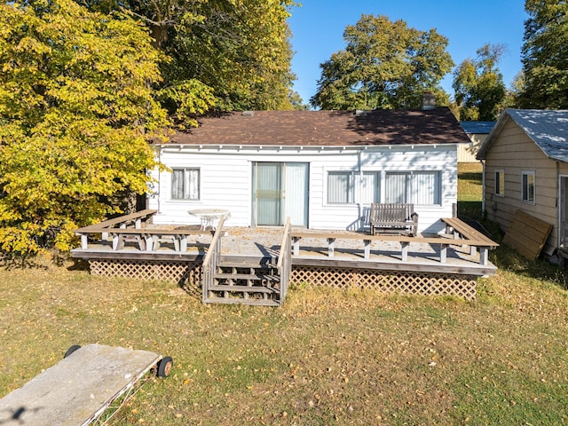 rear view of property with a deck and a lawn