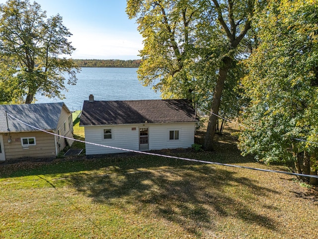 rear view of property featuring a yard and a water view