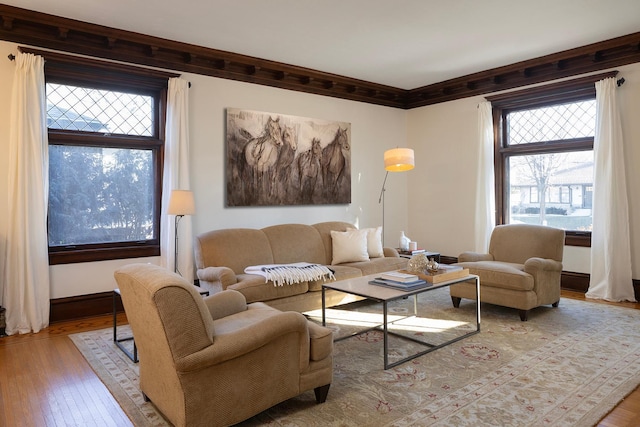 living room with plenty of natural light, light wood-type flooring, and crown molding