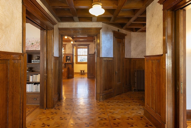 corridor featuring wooden walls, parquet floors, radiator, and coffered ceiling