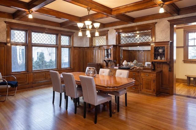 dining room featuring radiator, light hardwood / wood-style floors, coffered ceiling, and an inviting chandelier