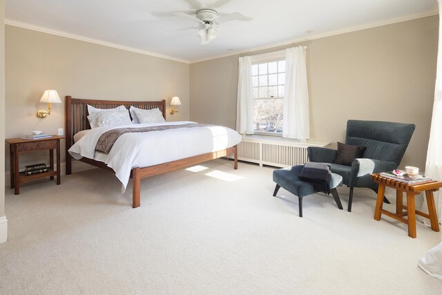 carpeted bedroom with radiator heating unit, ceiling fan, and ornamental molding