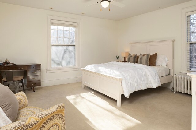 bedroom featuring radiator, ceiling fan, and light carpet