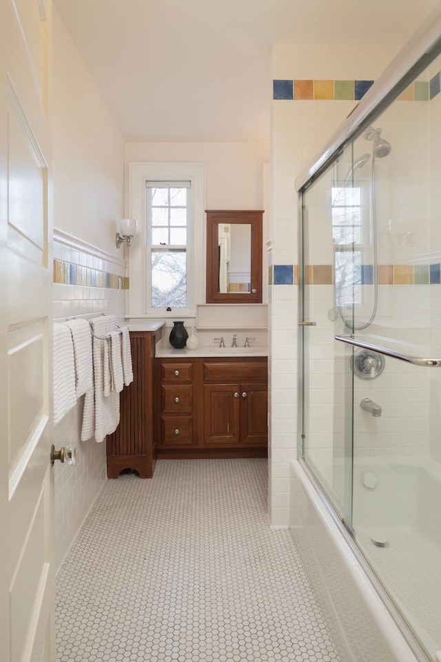 bathroom featuring tile patterned flooring, vanity, and bath / shower combo with glass door