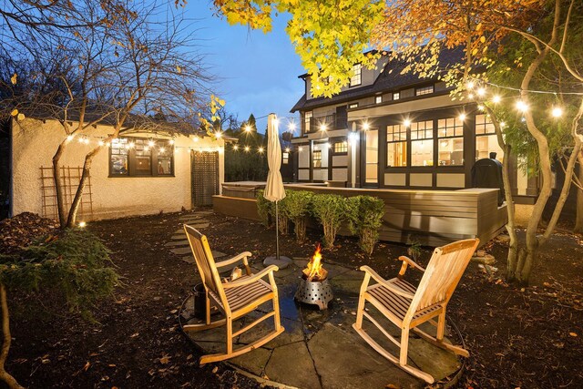 back house at dusk featuring a fire pit