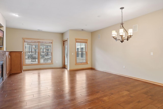 unfurnished living room featuring hardwood / wood-style floors and an inviting chandelier