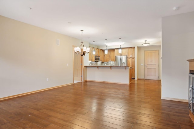 unfurnished living room featuring wood-type flooring and a notable chandelier