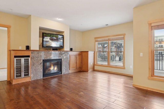 unfurnished living room with wood-type flooring and beverage cooler