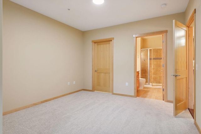 unfurnished bedroom with connected bathroom and light colored carpet