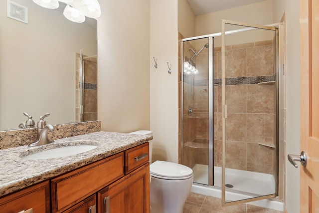 bathroom with tile patterned flooring, an enclosed shower, vanity, and toilet