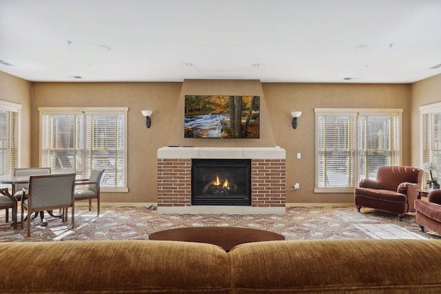 living room featuring a fireplace, a wealth of natural light, and light carpet