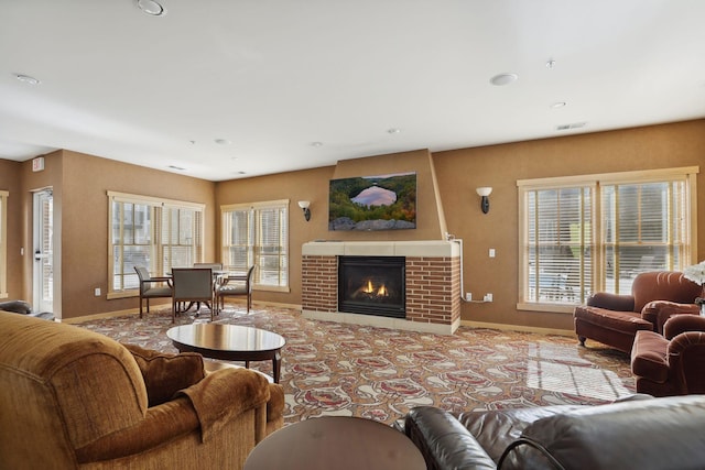 living room with a brick fireplace and plenty of natural light