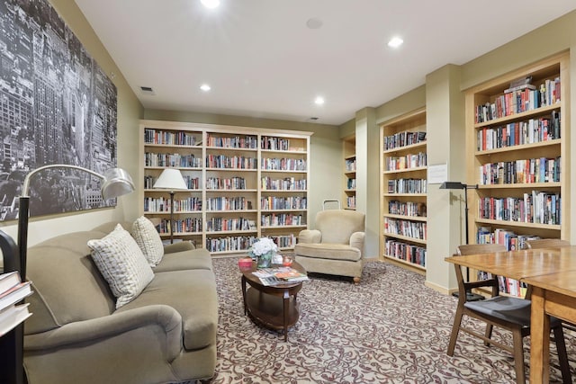 sitting room with built in shelves and carpet