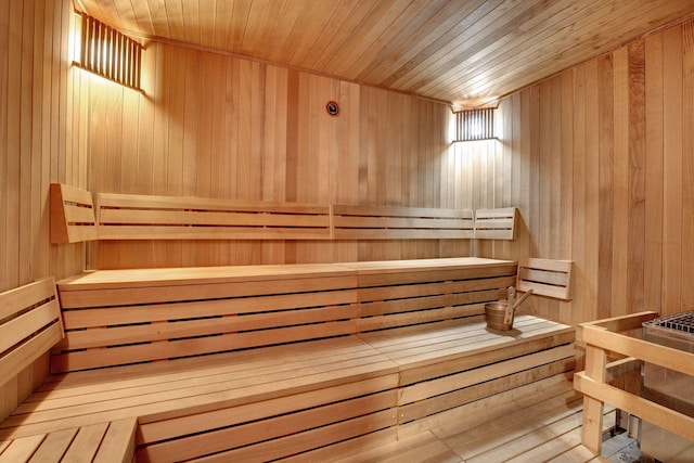 view of sauna with wooden ceiling and wood walls