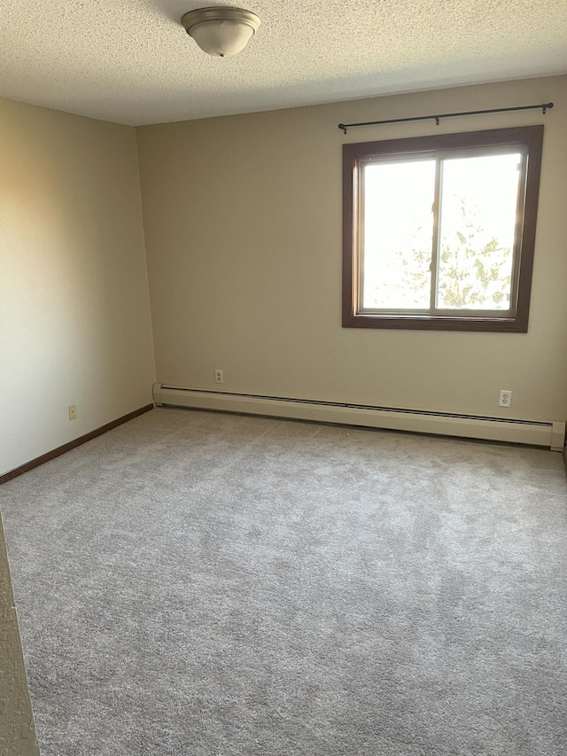 spare room featuring a textured ceiling, carpet flooring, and a baseboard radiator