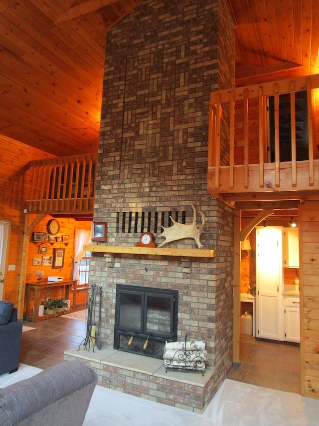 unfurnished living room featuring high vaulted ceiling, light tile patterned floors, wooden walls, and a brick fireplace