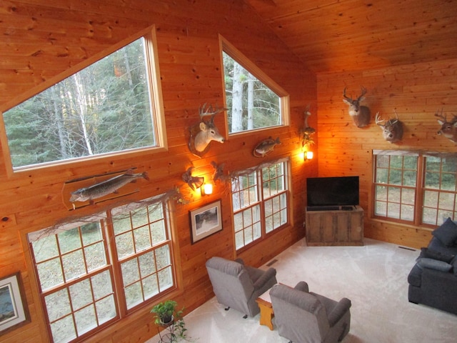 living room with carpet floors, wooden ceiling, vaulted ceiling, and wooden walls