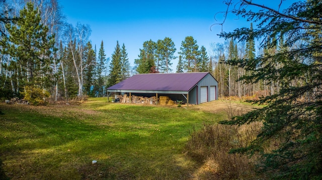 exterior space with a lawn, a garage, and an outdoor structure