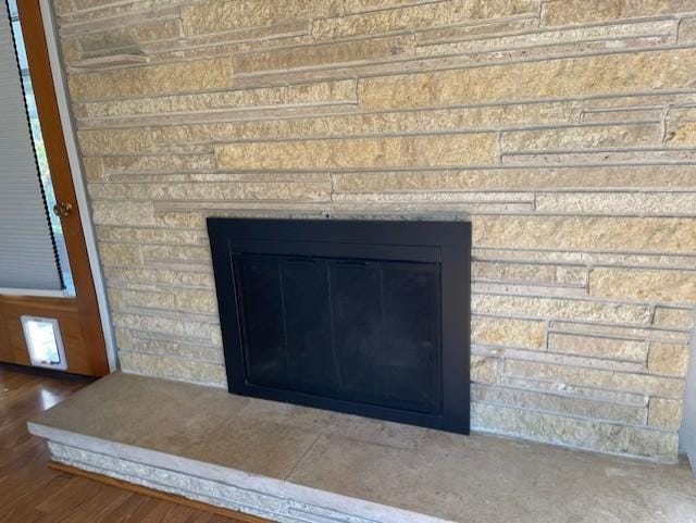 interior details with wood-type flooring and a fireplace