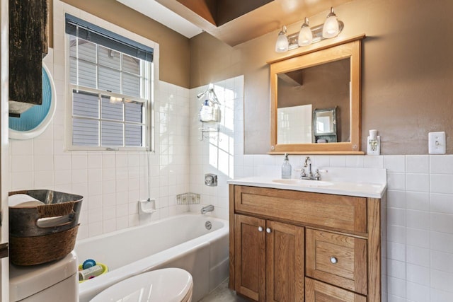 bathroom with vanity, toilet, and tile walls