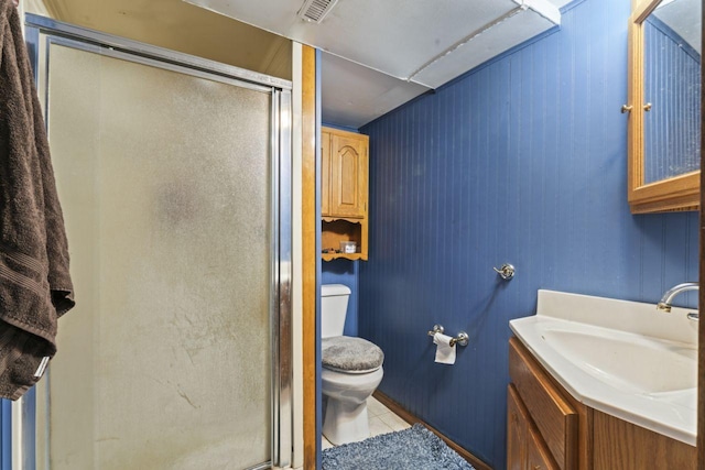 bathroom with toilet, tile patterned floors, wood walls, vanity, and walk in shower