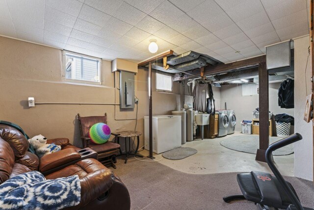 basement featuring electric panel, washer and dryer, and sink