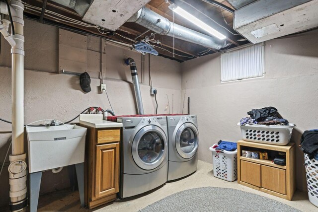 laundry area featuring cabinets, washing machine and dryer, and sink