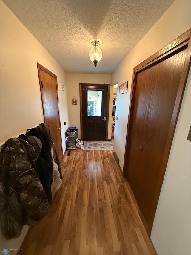 doorway to outside featuring a textured ceiling and hardwood / wood-style floors