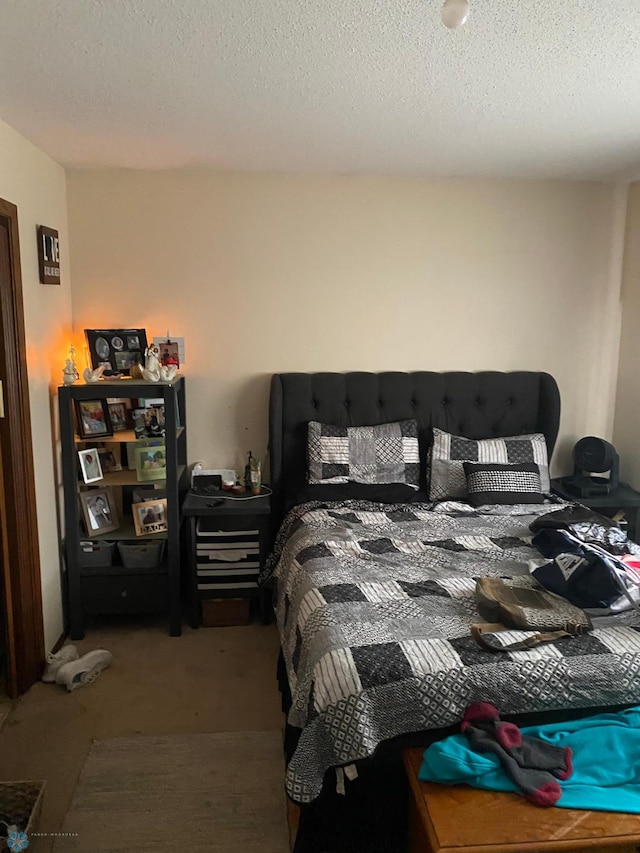 bedroom featuring carpet flooring and a textured ceiling