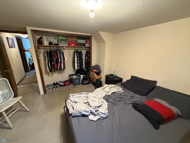 bedroom with concrete floors, a textured ceiling, and a closet