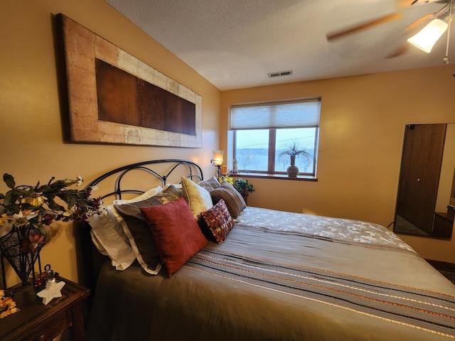 bedroom with a ceiling fan and a textured ceiling