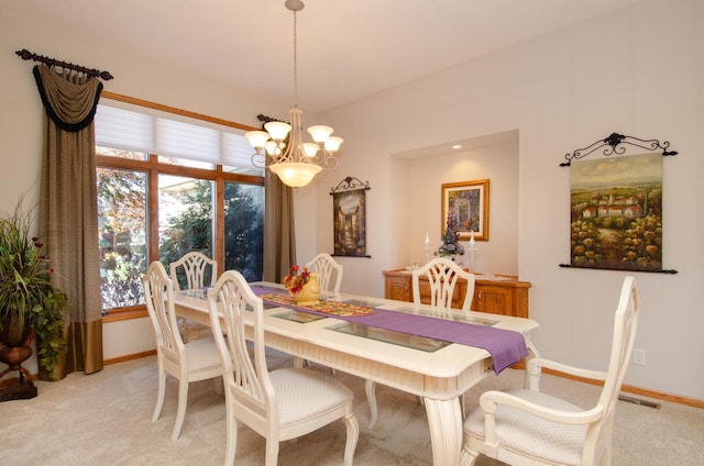 carpeted dining space with an inviting chandelier