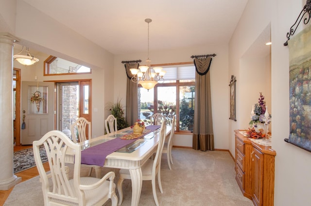 dining area with light carpet, a notable chandelier, plenty of natural light, and vaulted ceiling