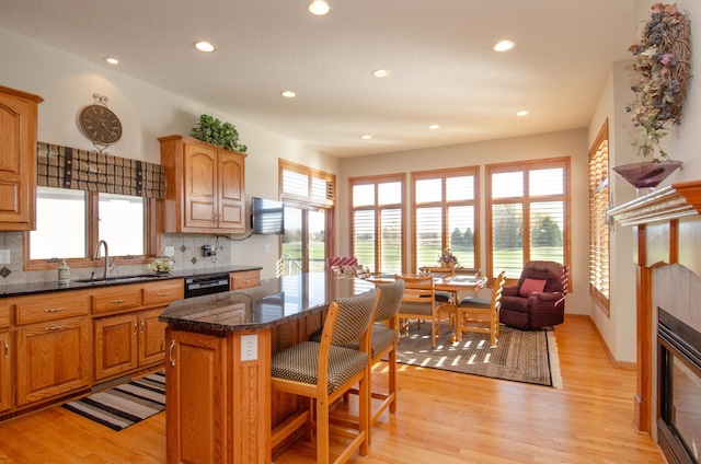 kitchen with sink, a center island, light hardwood / wood-style floors, and tasteful backsplash